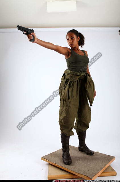 Woman standing holding a gun and rope outdoors in the desert. Young brutal  dangerous girl with a weapon in confident pose. War action movie style  beautiful armed female soldier dressed in stylish