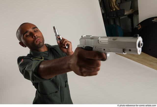 Portrait of man posing with two guns in an indoor shooting range stock photo