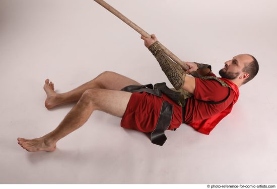 Man Adult Average White Fighting with spear Laying poses Casual