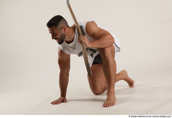 Man Adult Muscular Fighting with spear Kneeling poses Coat Latino