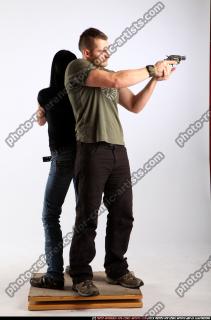 2010 02 COUPLE STANDING AIMING GUNS2 06 B