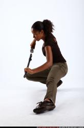 Woman Young Athletic Black Fighting with sword Kneeling poses Casual