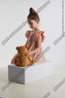 Sitting little girl with teddy bear Doroteya